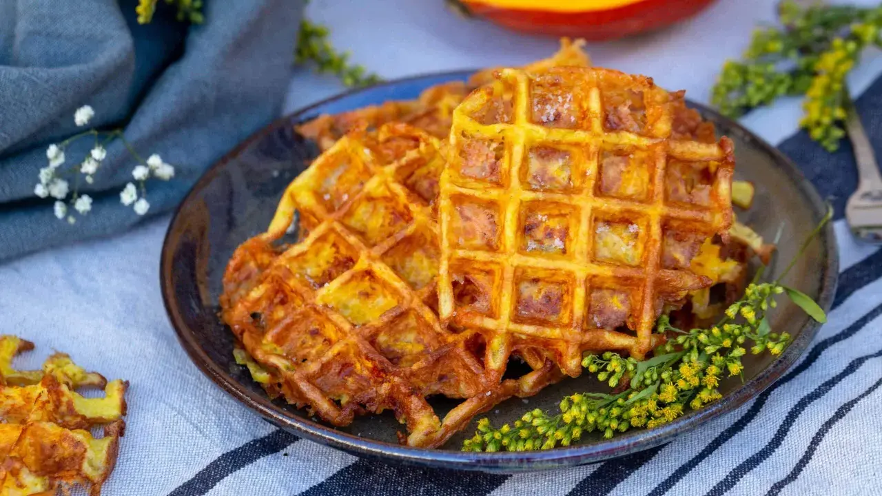 Gaufres dorées et croustillantes, une délicieuse gaufre potimarron salé, garnie de petites fleurs jaunes.
