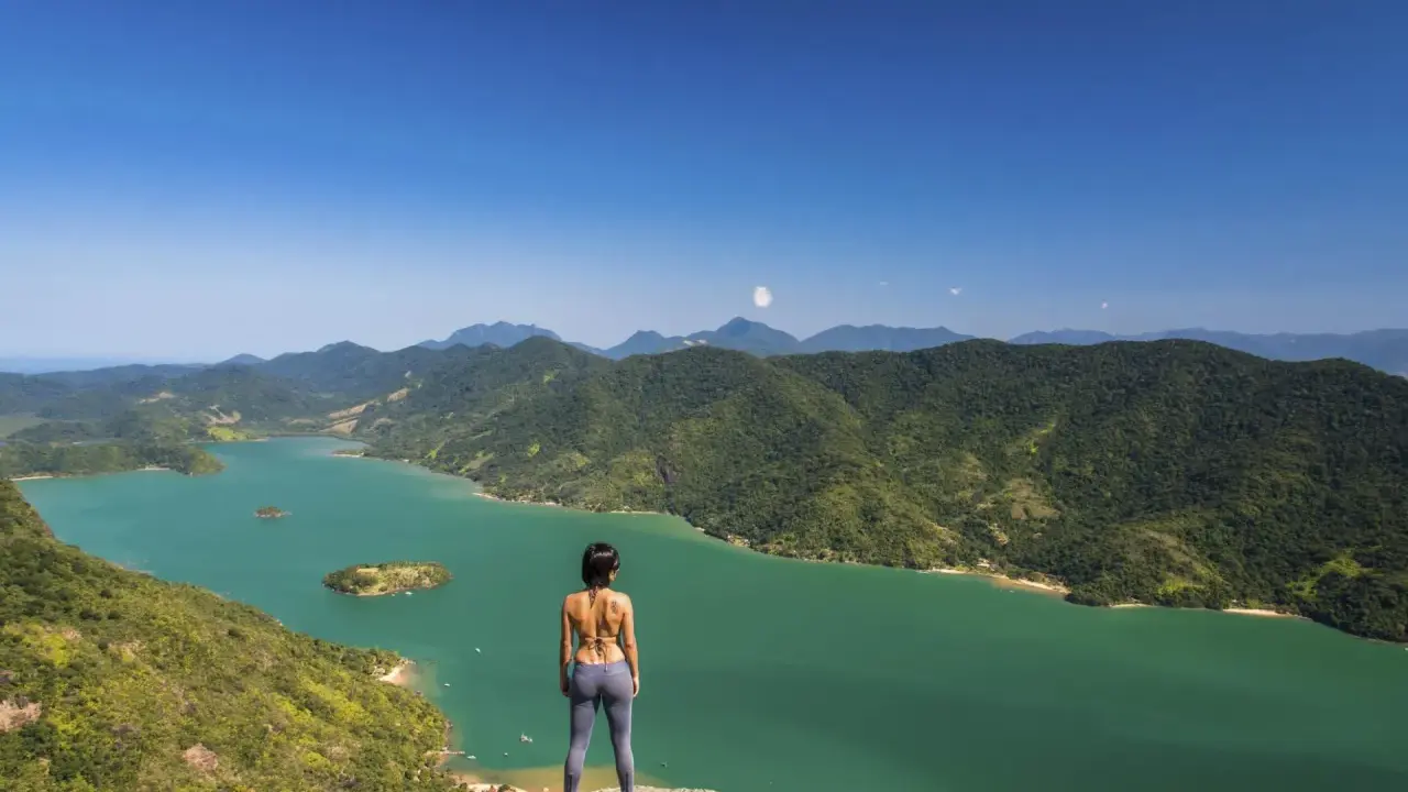 Frauenblick auf die grüne Bucht von Paraty, Brasilien, mit bewaldeten Bergen und Inseln.