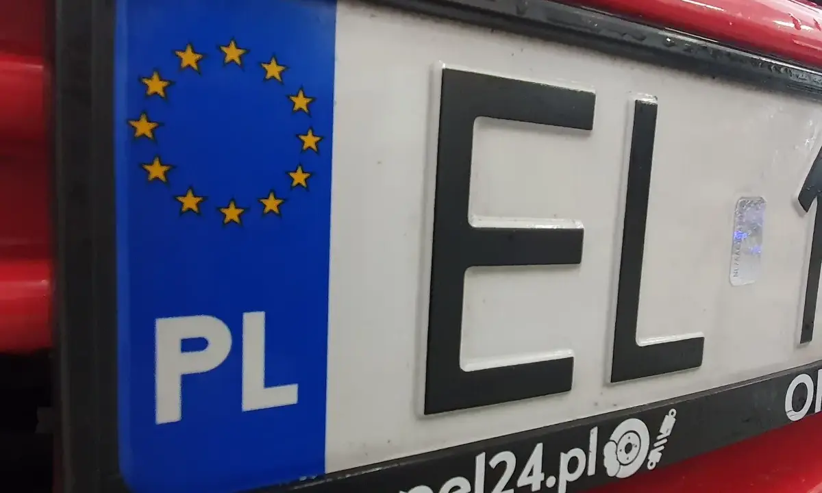 Zbliżenie na polską tablicę rejestracyjną z symbolem UE i literami "EL". To ważny element identyfikacyjny pojazdu, umożliwiający jego rejestrację.