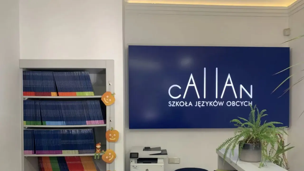 Szkoła językowa oferująca angielski metodą Callana. Na półkach książki, obok dynie. Na ścianie logo szkoły.