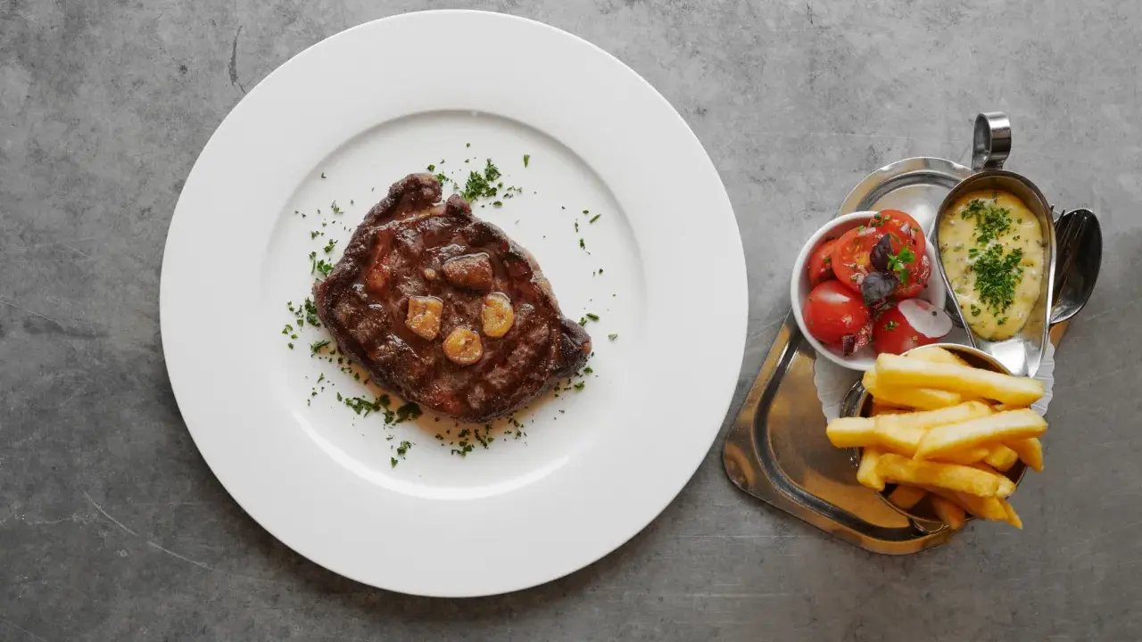 En saftig biff med vitlök, pommes frites, tomatsallad och bearnaisesås. En måltid som får en att vilja skriva restaurang Prinsens recensioner.