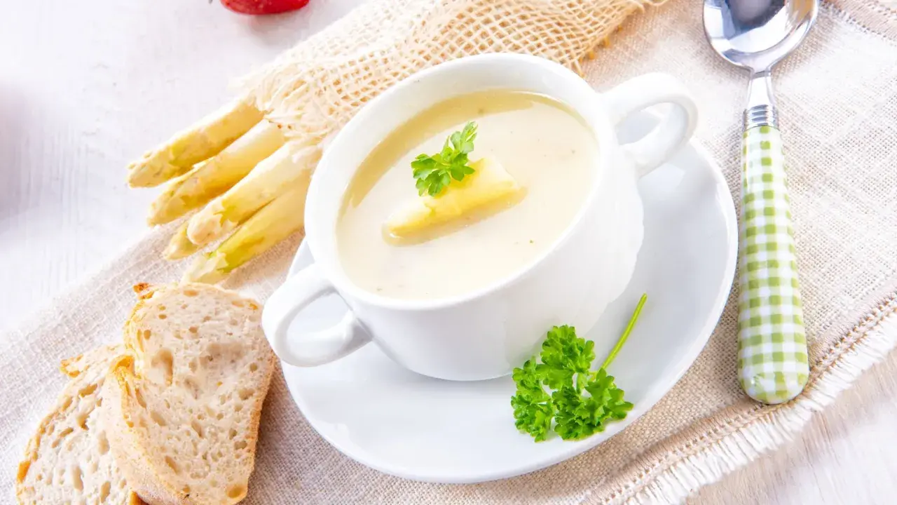 Cremige Spargelsuppe mit frischem Spargel, Brot und Petersilie. Ein köstliches Spargelsuppe Rezept für Genießer.