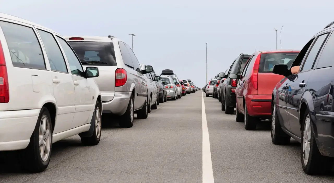 Fila de coches en carretera. Evita la multa por adelantar en línea continua.