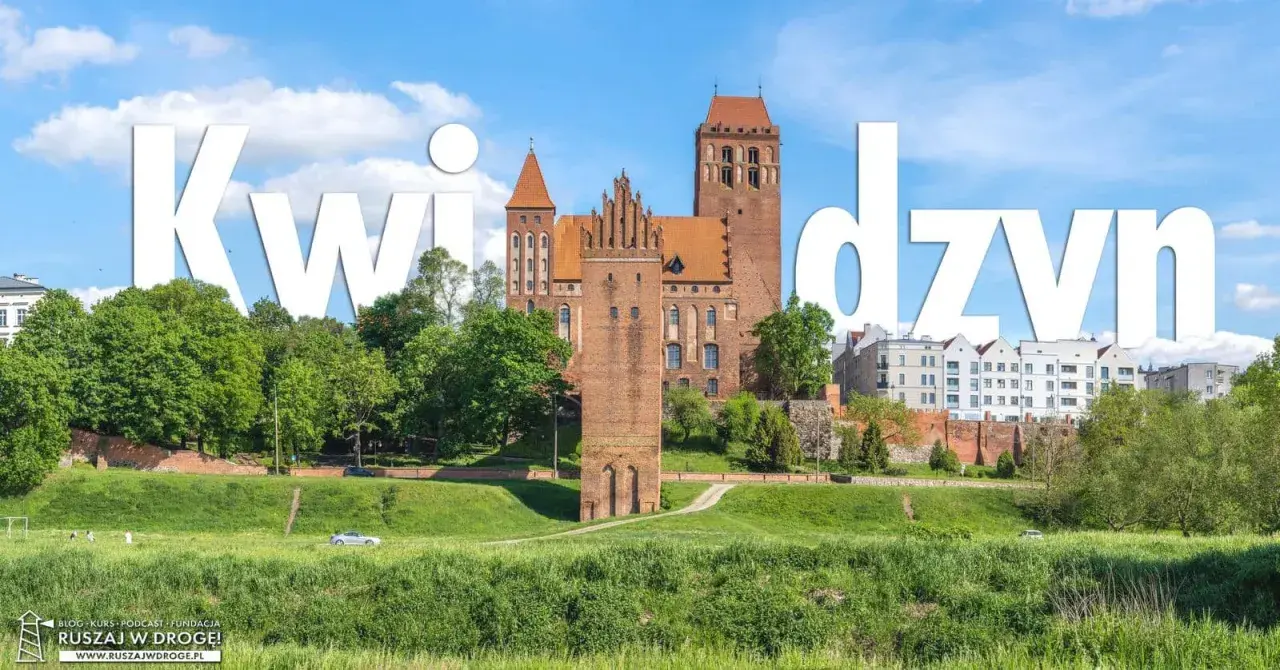 Zamek w Kwidzynie, imponująca budowla z cegły, góruje nad zielonym krajobrazem.