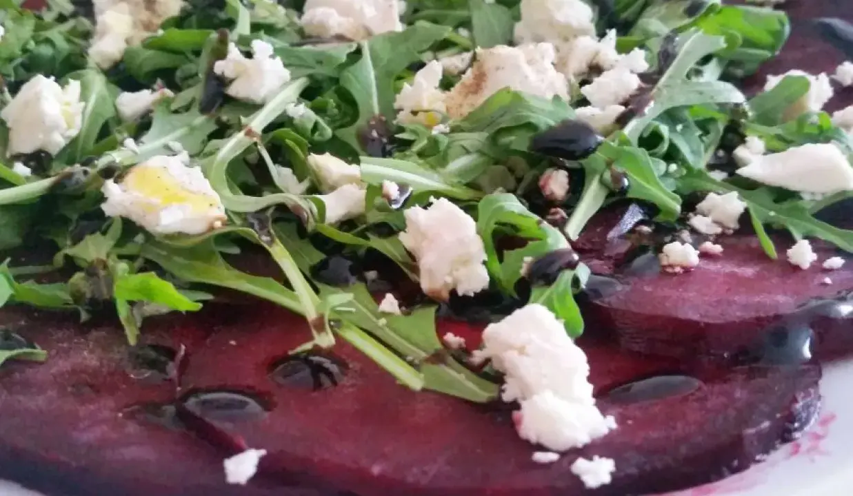 Carpaccio z buraka z fetą i rukolą, polane sosem balsamicznym.