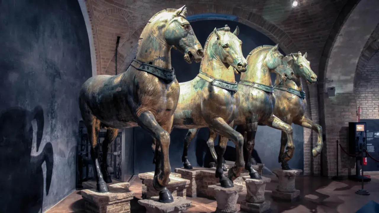 Les célèbres chevaux de Saint-Marc, statues de bronze patiné, se dressent fièrement dans un musée, leurs corps musclés capturant l'essence de la puissance antique.