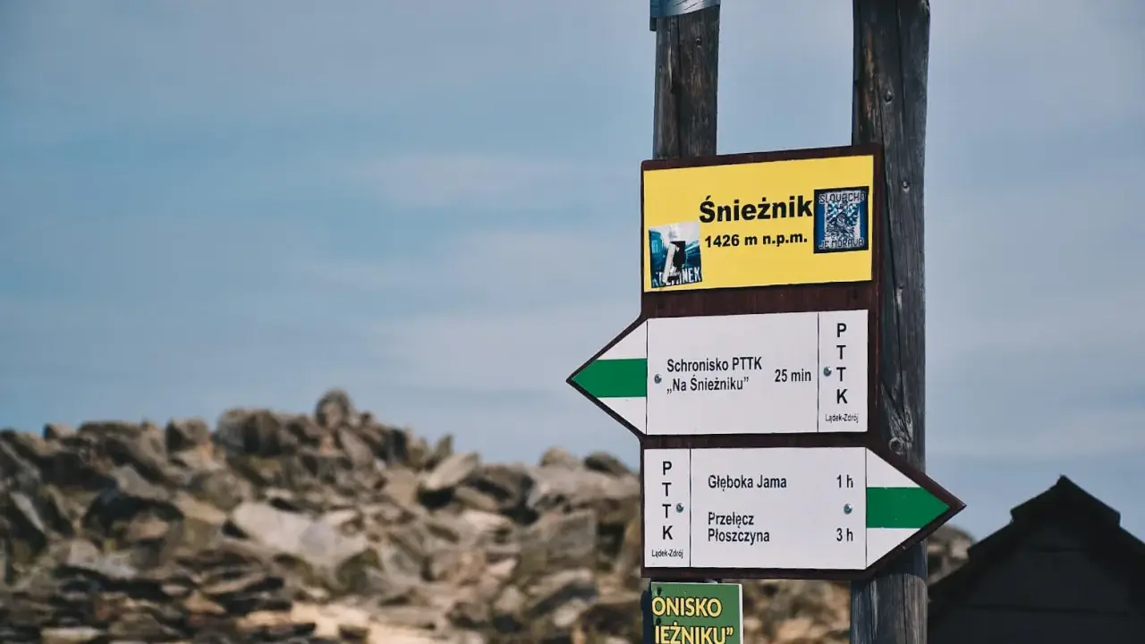 Znak drogowskazów na Śnieżnik, 1426 m n.p.m. Wskazuje drogę do schroniska "Na Śnieżniku" i na Przełęcz Płoszczynę.