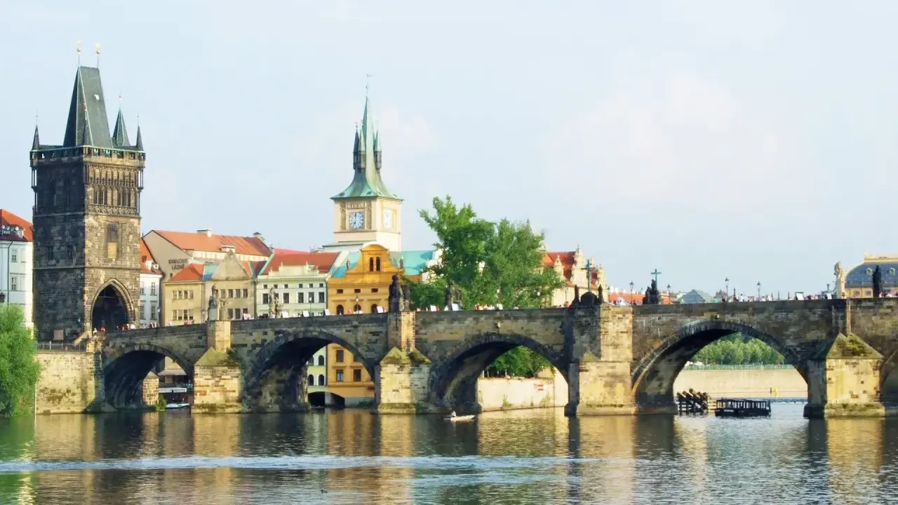 Most Karola w Pradze, z wieżą i zabytkowymi budynkami. To piękne informacje o Czechach.