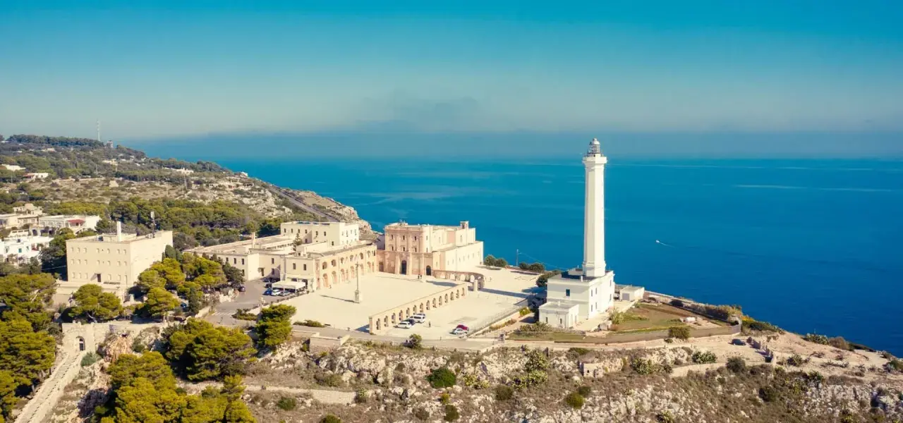 Il santuario e il faro di Santa Maria di Leuca dominano il lungomare, con il blu intenso del mare sullo sfondo.