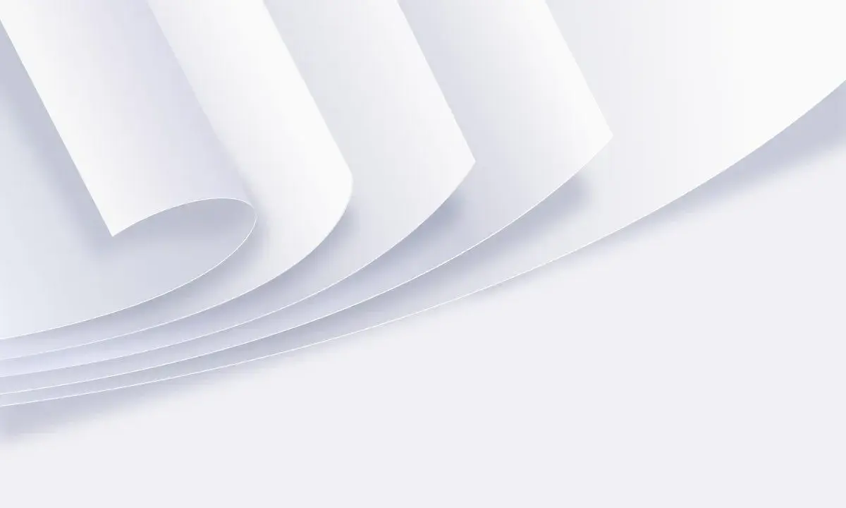 Stos białych kartek papieru zwiniętych w rogu.