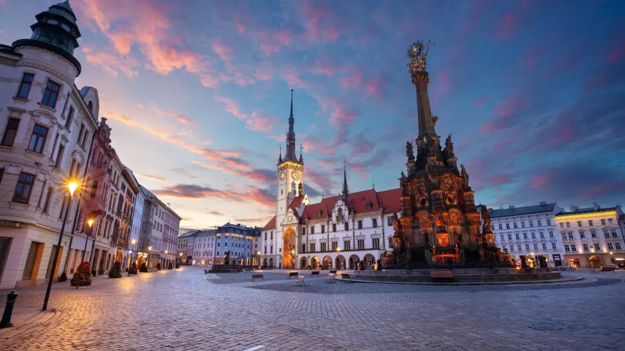 Rynek w Ołomuńcu, perle Moraw Południowych, o zachodzie słońca. Majestatyczna kolumna Trójcy Świętej i ratusz w blasku lamp.