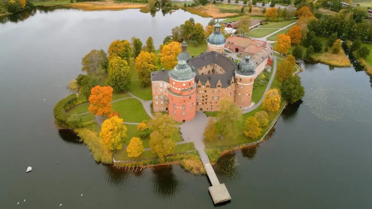 En vacker utflykt till Uppsala med ett slott omgivet av höstfärger och vatten.
