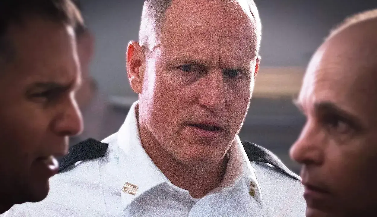 Woody Harrelson i en vit skjorta, omgiven av andra män. En scen från filmer och tv-program med Woody Harrelson.