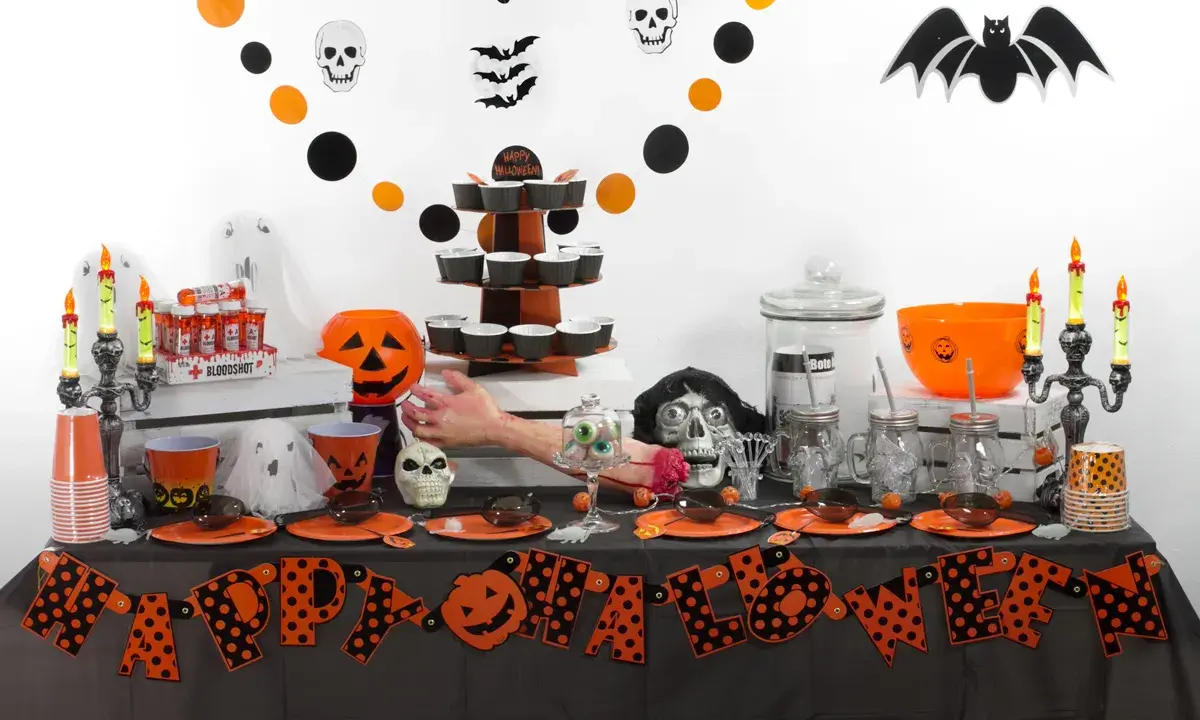 Mesa de **manualidades chuches Halloween** con calabazas, fantasmas, calaveras y dulces.