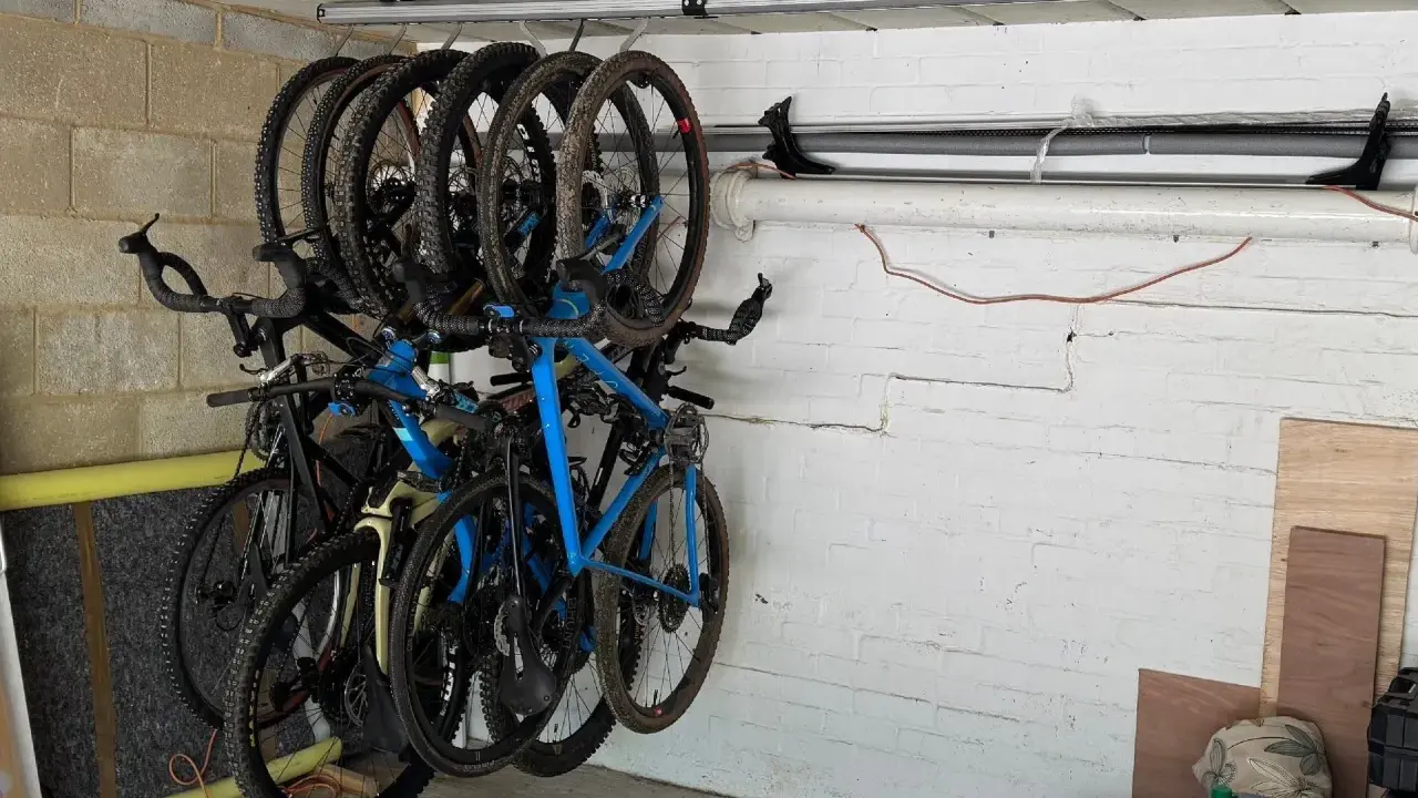 Système de rangement astucieux pour vélos dans un garage, plusieurs vélos suspendus au plafond pour optimiser l'espace.