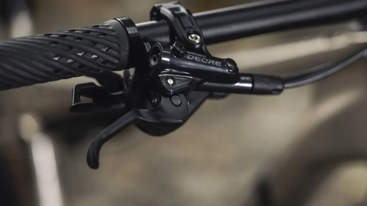Manetka Shimano Deore, część mechanizmu zmiany biegów, pokazuje różne rodzaje przerzutek rowerowych w akcji.