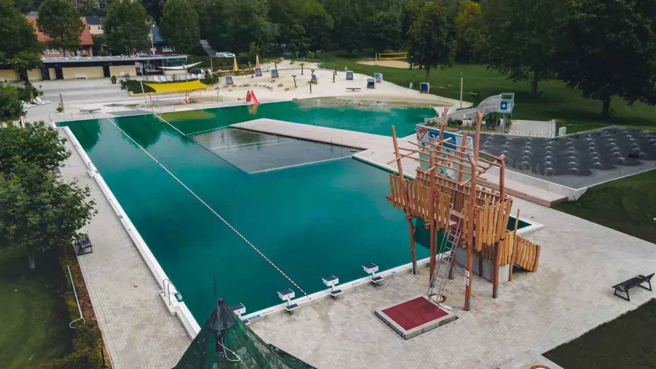 Das freibad ennigerloh bietet Badespaß mit großem Becken, Wasserrutsche, Sandstrand und Klettergerüst.