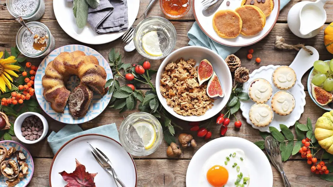 Leckere Brunch-Idee: Marmorkuchen, Müsli, Pancakes, Obst und ein Spiegelei auf rustikalem Holztisch.
