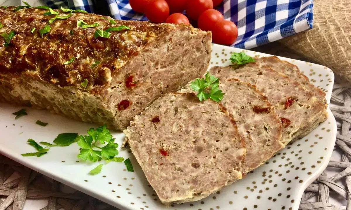 Pyszna pieczeń rzymska na kanapki, pokrojona w plastry, ozdobiona natką pietruszki. Idealna na śniadanie lub kolację.