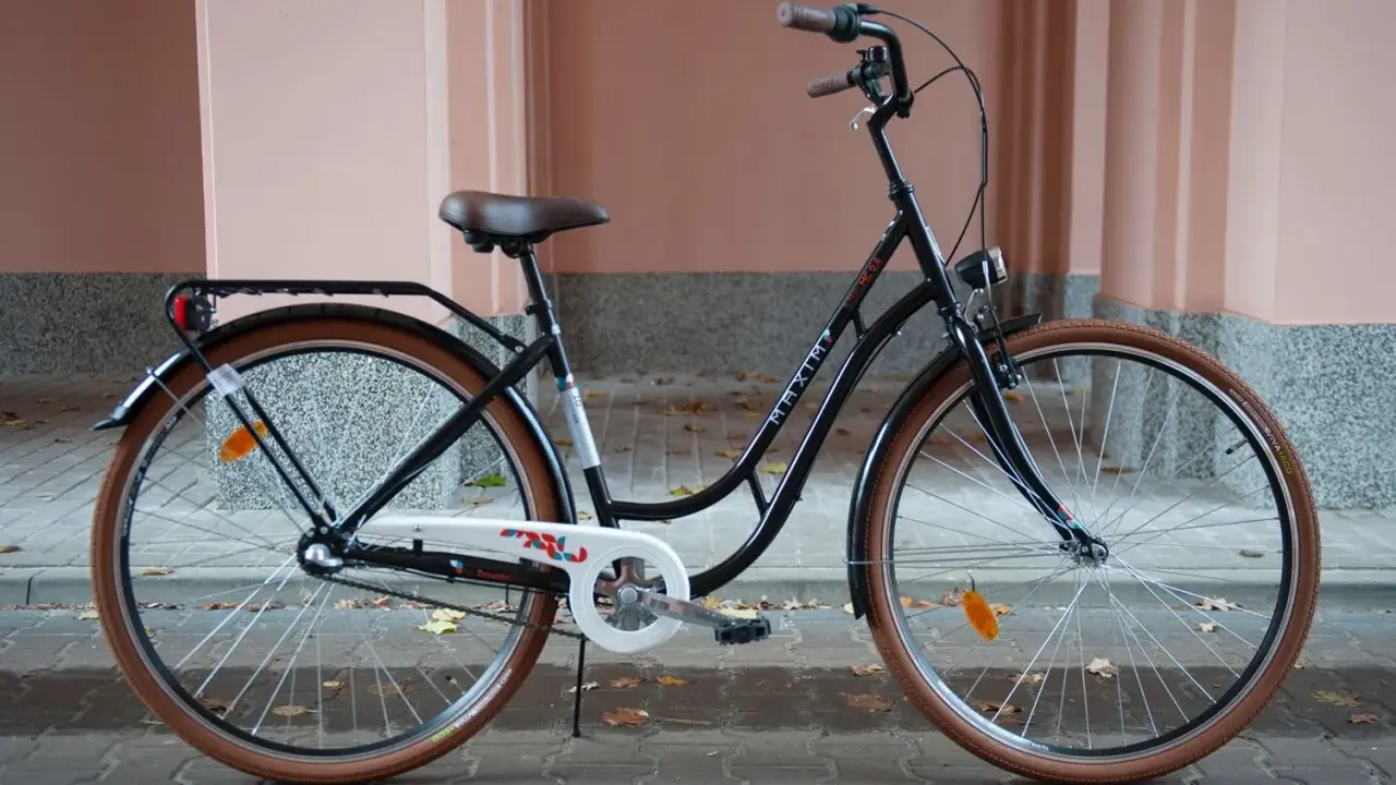 Elegancki, czarny rower do miasta z brązowymi oponami i wygodnym siodełkiem. Idealny na codzienne dojazdy.
