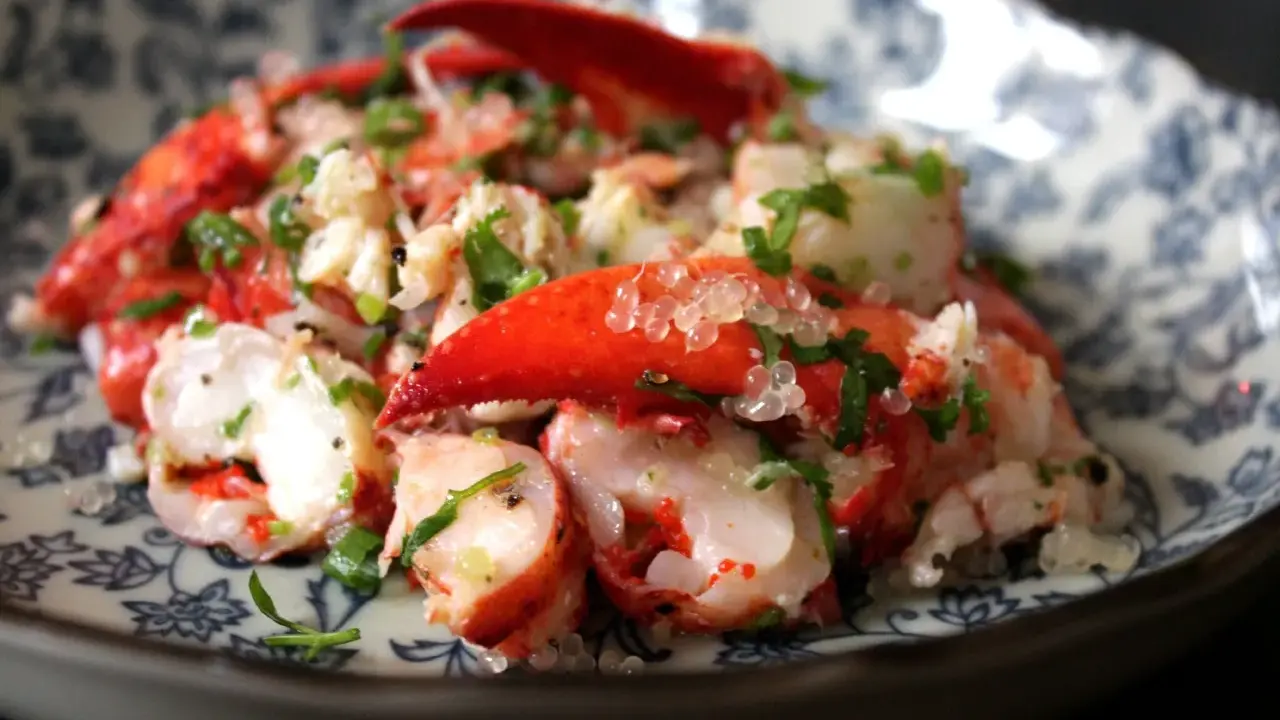 Homard frais servi avec des perles de citron caviar, une recette raffinée pour un plat d'exception.