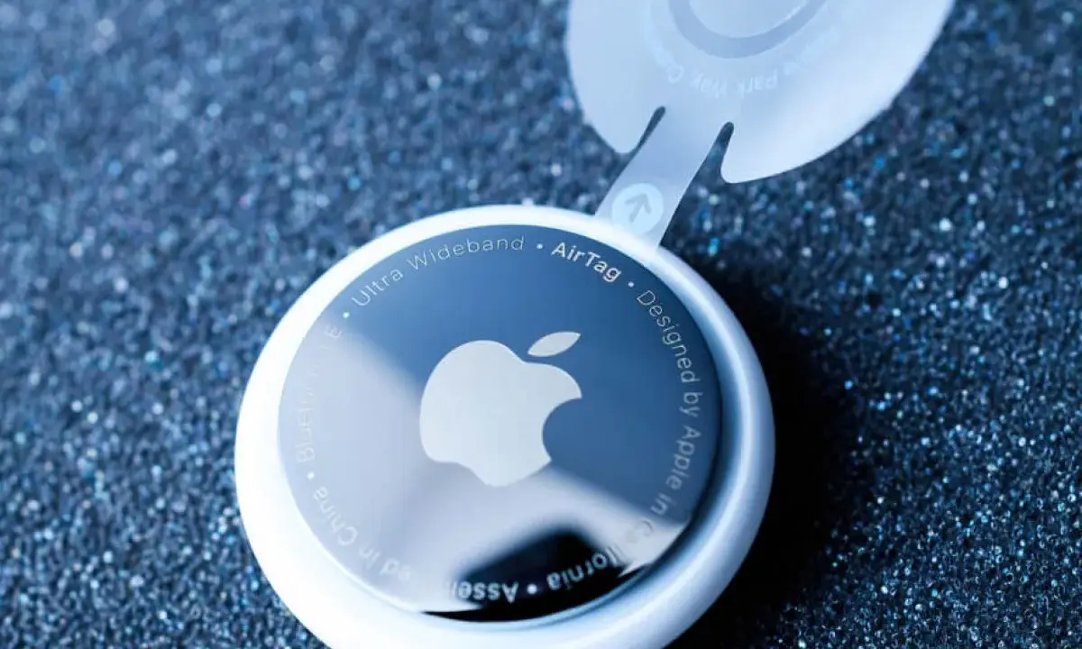 Biały AirTag z logo Apple, pokazujący, jak działa AirTag. Urządzenie z technologią Ultra Wideband.
