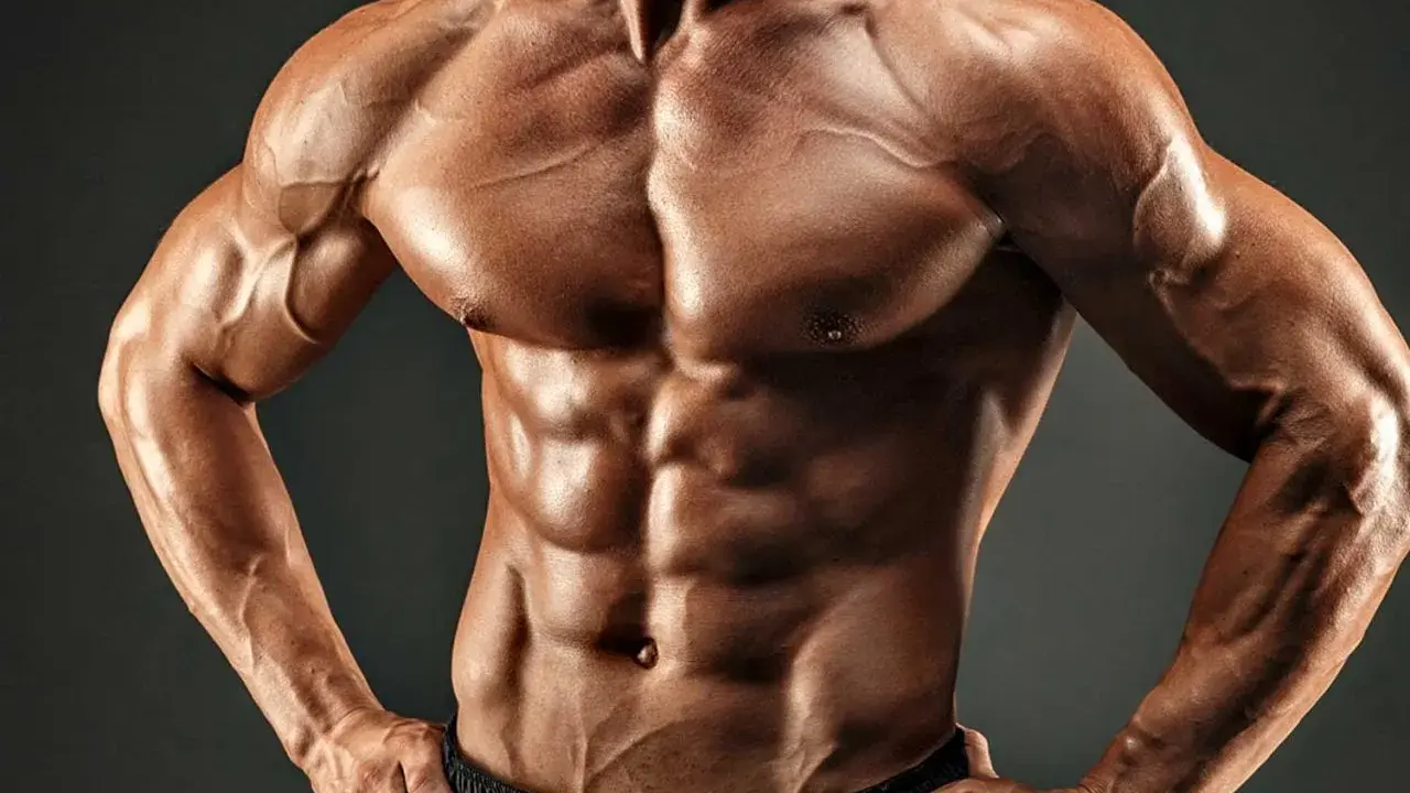 Ein Mann mit einem definierten Sixpack und starker Brustmuskulatur, das Ergebnis harter Arbeit und Disziplin.