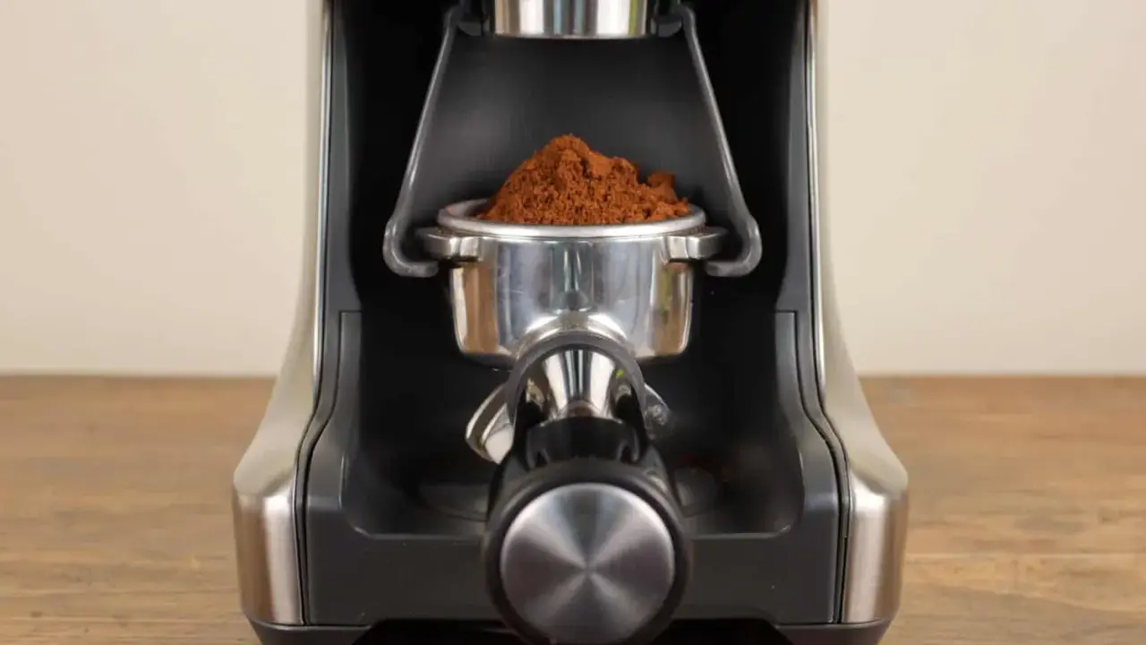 Nahaufnahme des Siebträgers mit frisch gemahlenem Kaffee, bereit zur Einstellung des Sage Smart Grinder Pro.