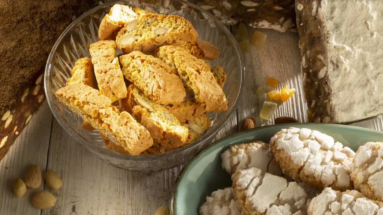 Biscotti e amaretti, deliziosi dolci toscani, su un tavolo di legno.