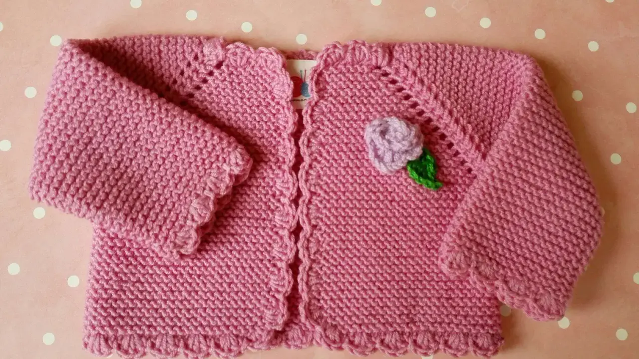 Chaqueta a crochet para bebé de 3 a 6 meses, rosa con flor lila y hoja verde. Ideal para abrigar a tu pequeño con estilo.