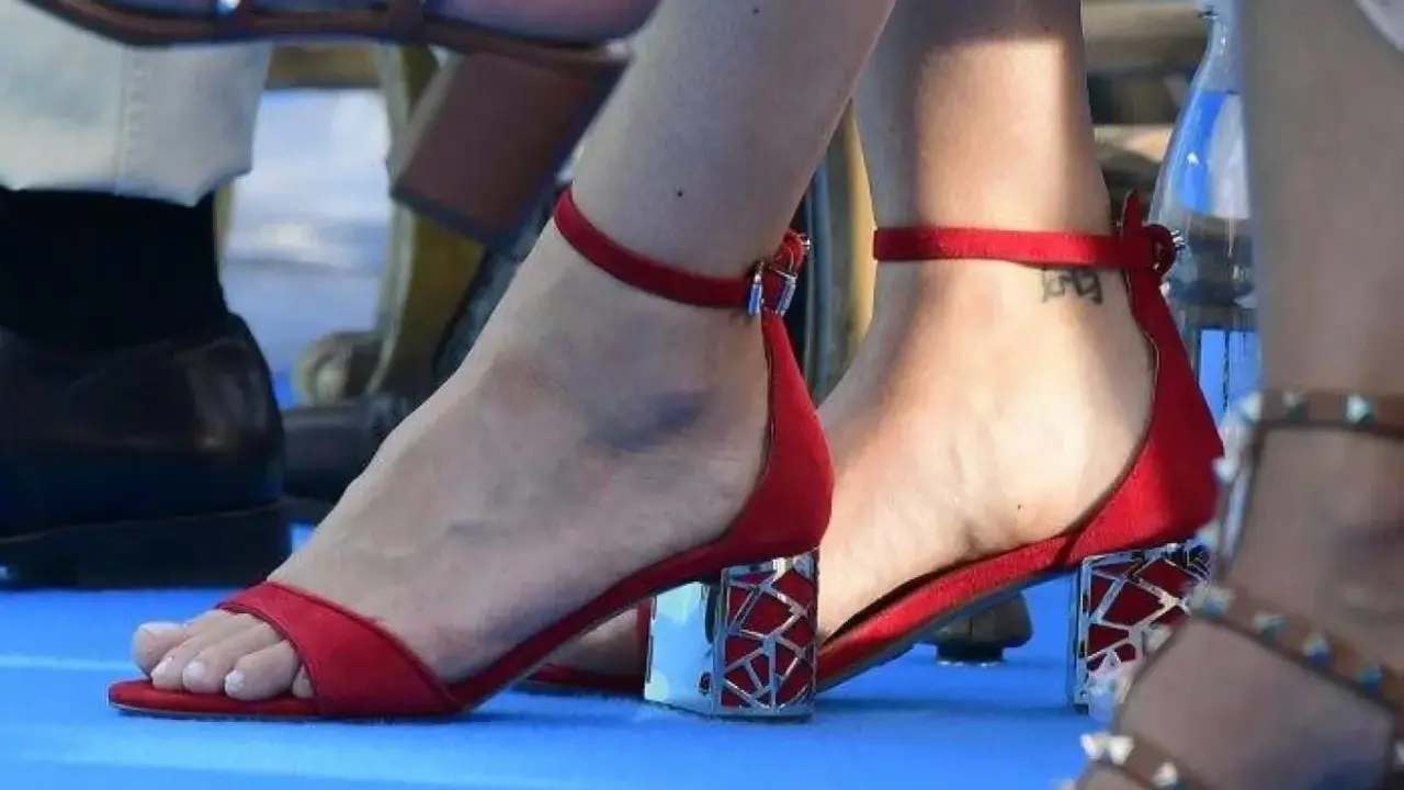 Röda sandaler med en liten tatuering på fotleden, kanske en hyllning till prinsessan Sofia.