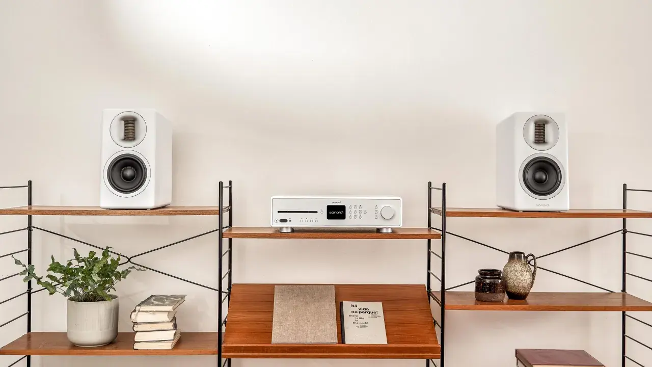 Élégant système audio blanc avec deux enceintes hifi et un lecteur CD sur des étagères en bois.