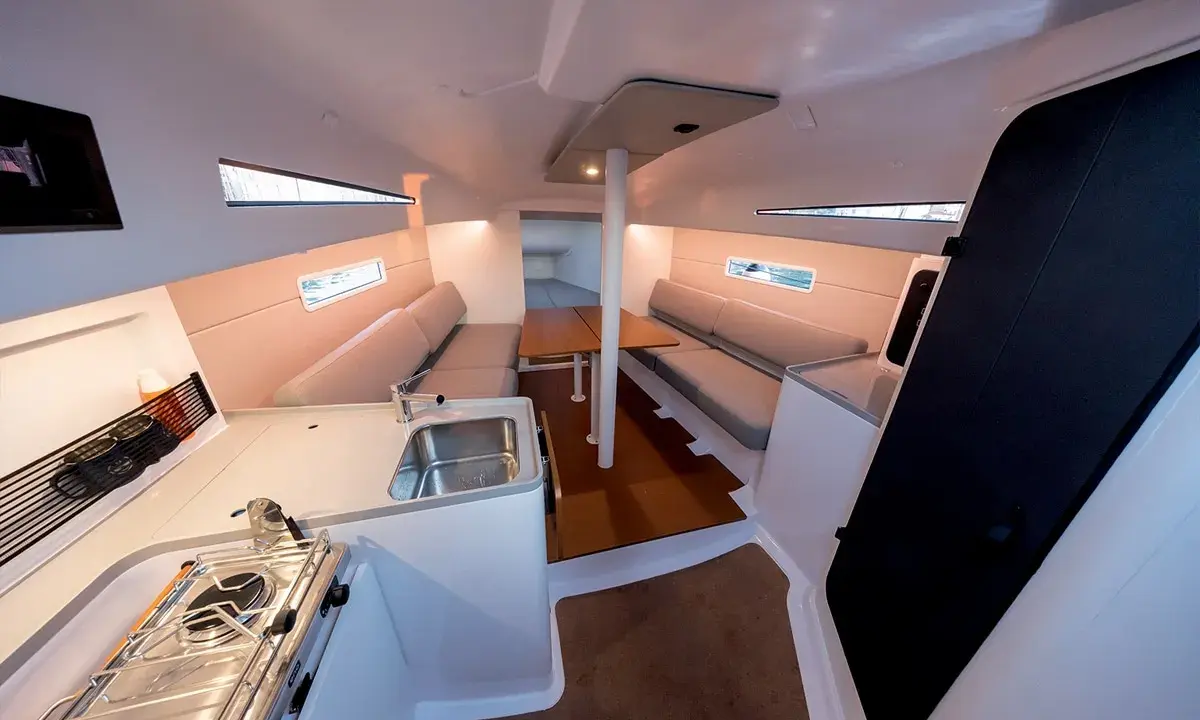 Intérieur d'un voilier moderne, avec cuisine, salon et table. Les premiers 30 pieds offrent un espace confortable pour la vie à bord.