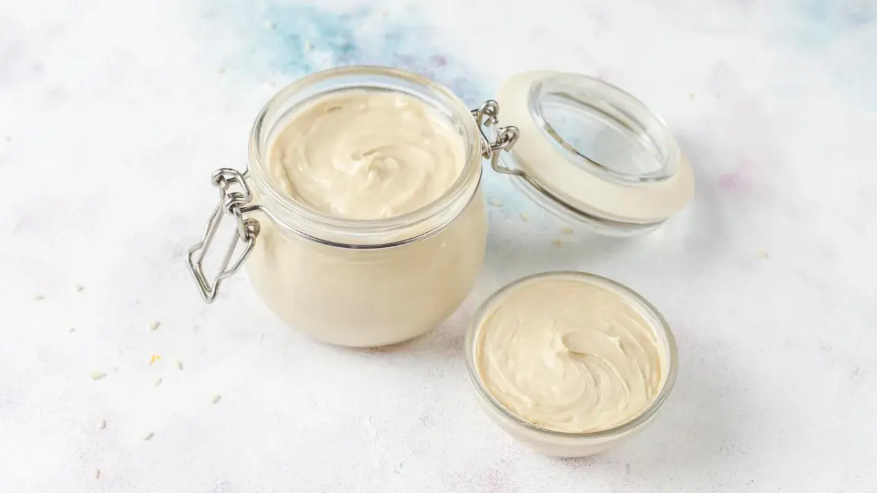 Crème pâtissière onctueuse dans un bocal et un bol. Parfait pour une recette de crème pâtissière facile et rapide.