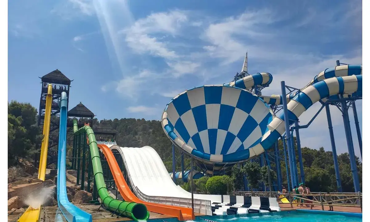 Toboganes acuáticos de colores vibrantes y una piscina azul cristalina, ideal para saber qué hacer en Benidorm con niños y disfrutar de un día refrescante.