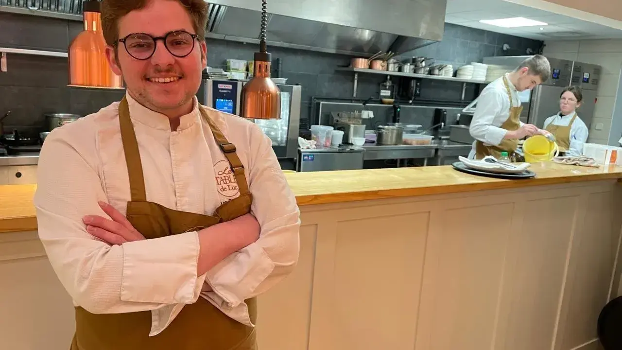 Le chef souriant du restaurant Le Mans, avec son équipe en cuisine.