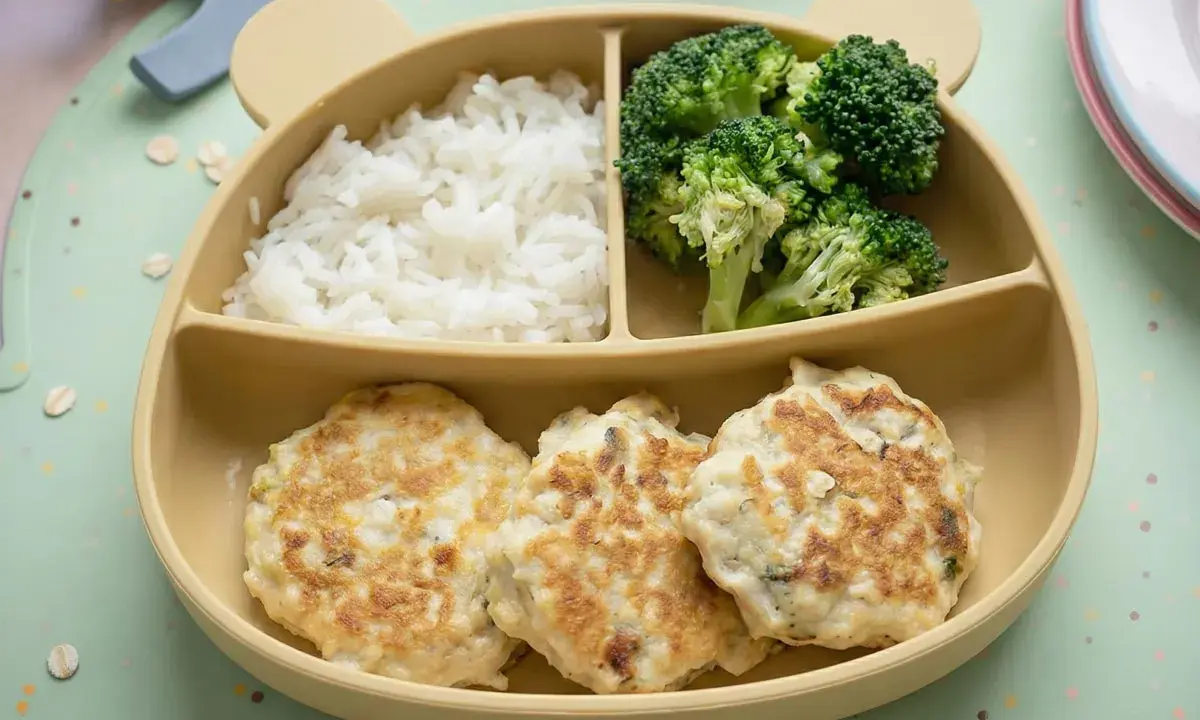 Deliciosas hamburguesas de pollo caseras para niños, acompañadas de arroz blanco y brócoli, servidas en un plato con forma de oso.