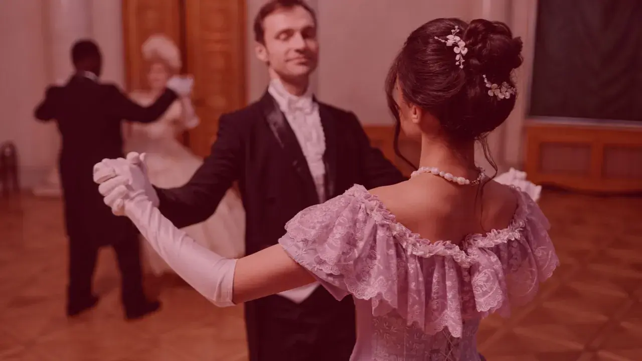 Elegancka para tańczy powolny walc na balu. Ona w pastelowej sukni, on w fraku.