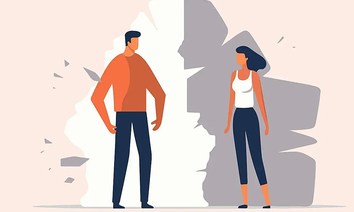 Hombre y mujer separados por una pared rota, simbolizando problemas de pareja.