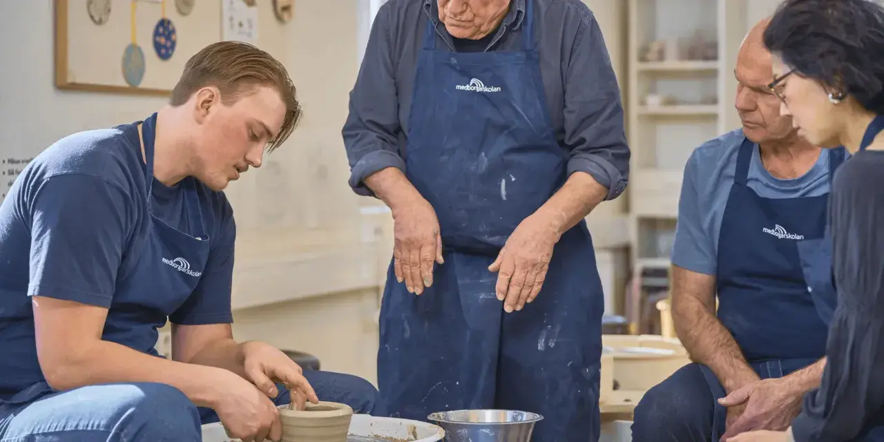 En ung man lär sig tumning keramik på en kurs. En äldre man och en kvinna tittar på.