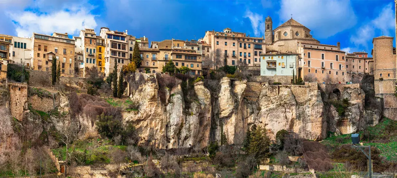 Häuser klammern sich an steile Felsen in Cuenca, Spanien. Eine Kathedrale thront über der Stadt.