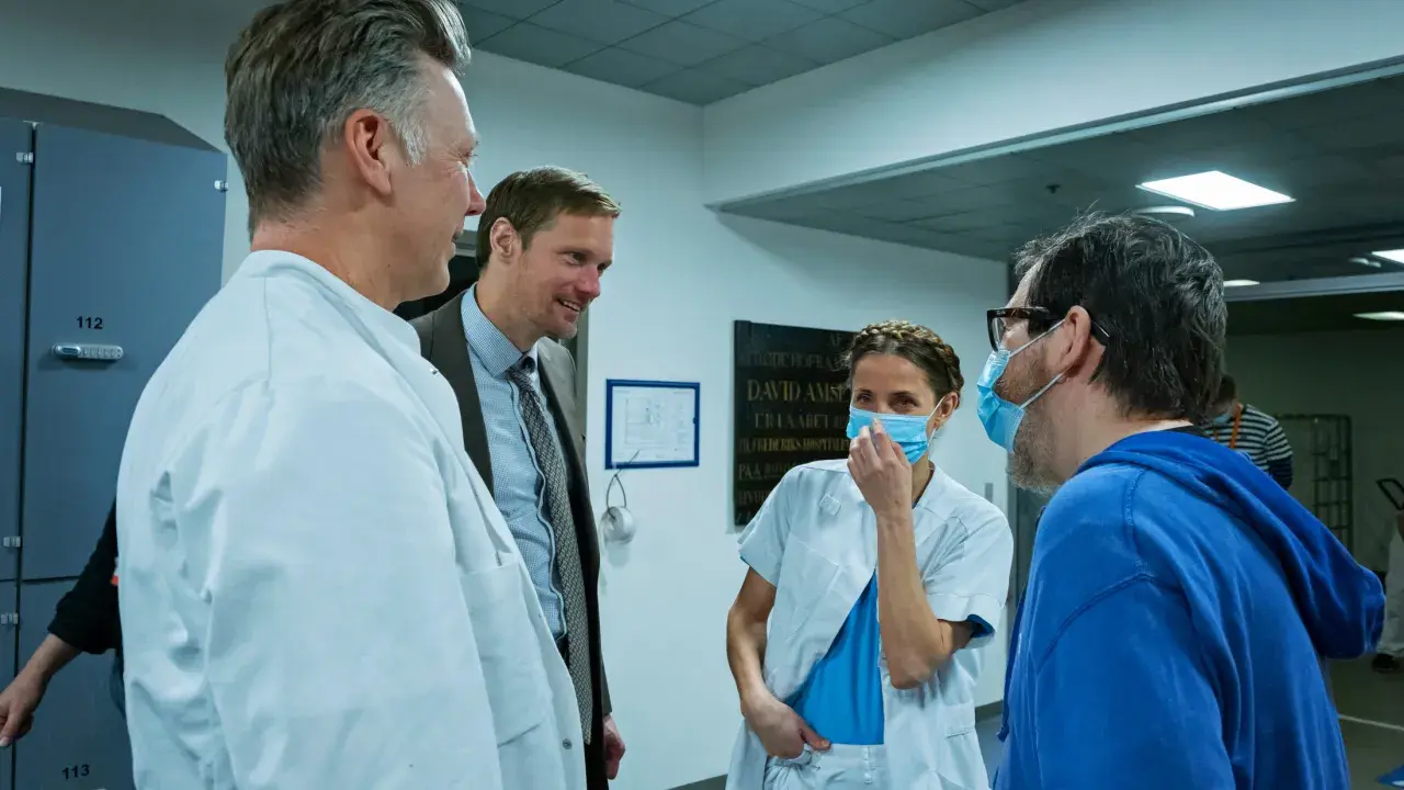 Tuva Novotny och Alexander Skarsgård i samtal med sjukhuspersonal.