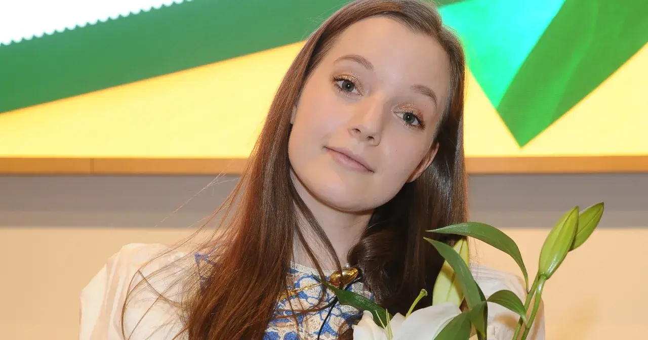 Sanah z bukietem białych lilii, uśmiechnięta, jakby przeżywała najlepszy dzień w moim życiu.