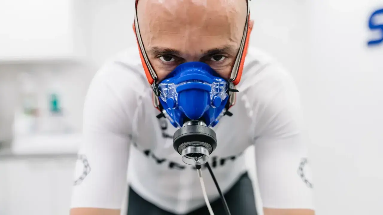 Mężczyzna w masce do testów wydolnościowych, badanie VO2 max. Intensywny wysiłek w celu poprawy kondycji.