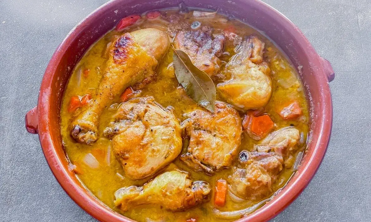 Muslos de pollo en salsa, un plato casero que evoca la receta de la abuela. Jugosos trozos de pollo dorados en una rica salsa con zanahorias y laurel.