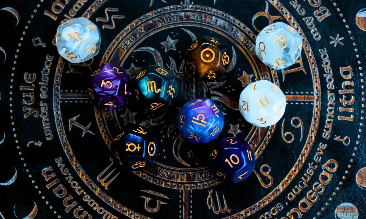 Kolorowe kości do gry na tle zodiaku. Czy to zapowiedź horoskopu tygodniowego dla Wagi?