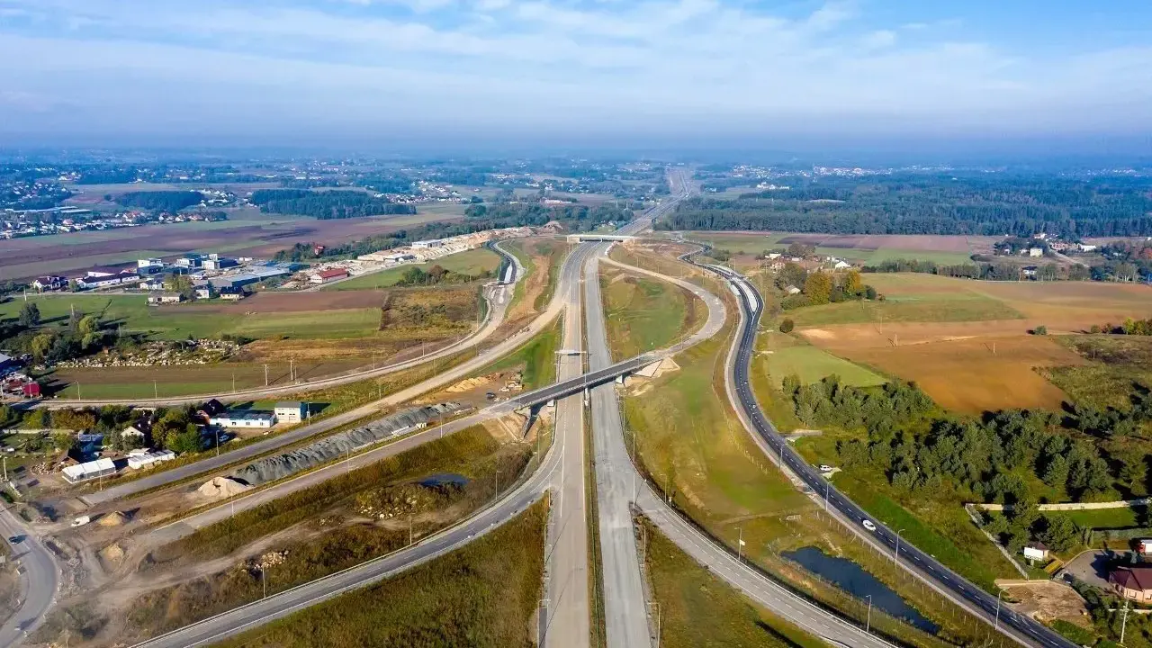 Rozbudowa trasy gdańsk, widok z lotu ptaka na węzeł drogowy w otoczeniu pól i lasów.