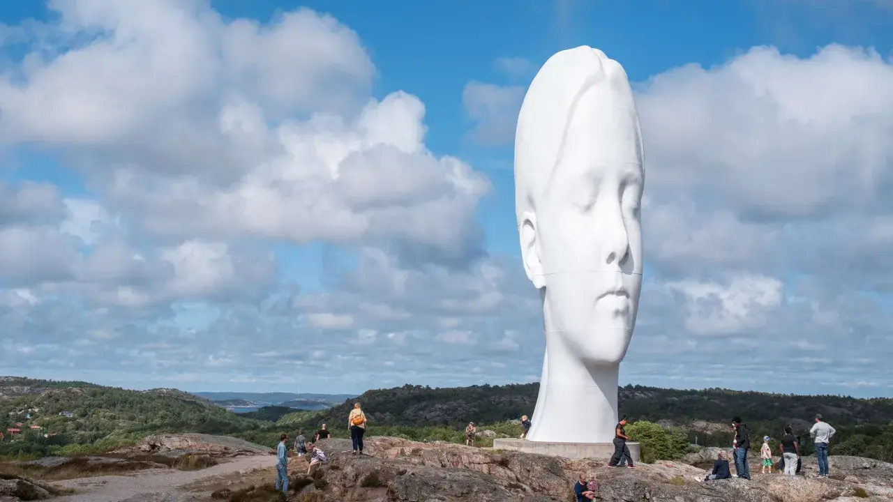 Enormt vitt ansikte reser sig mot en molnig himmel. En av de mest minnesvärda platserna att besöka i Göteborg.