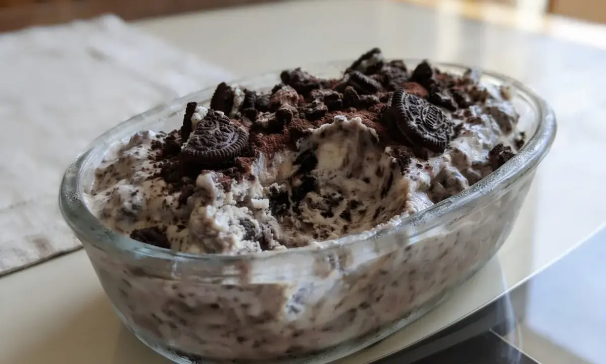 Pyszne lody oreo w szklanej misie, posypane pokruszonymi ciastkami i kakao. Idealne na deser!