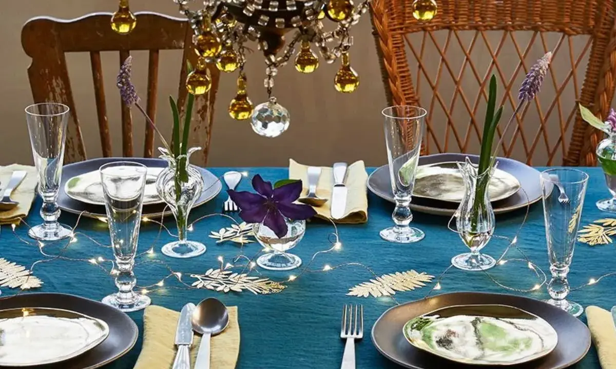 Une table dressée avec élégance, des verres étincelants et des fleurs délicates. L'art de la table est célébré sous un lustre scintillant.